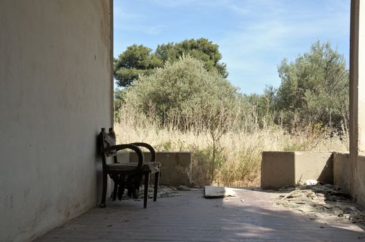 Abandoned summer house. Porch and lonely chair.