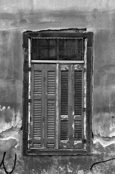 Vintage window shutters and grungy abandoned house wall. Black and white.