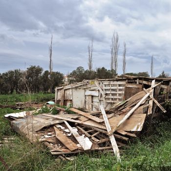 Collapsed old wooden hut and overcast sky.