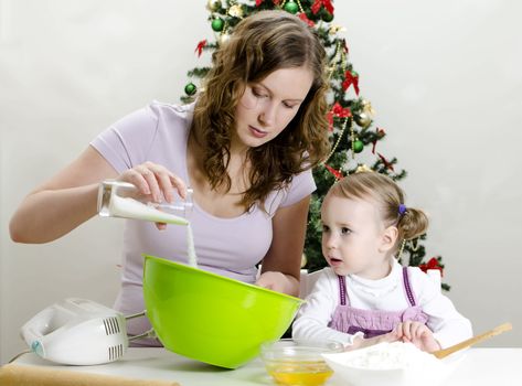 little girl and mother are preparing Christmas cookies