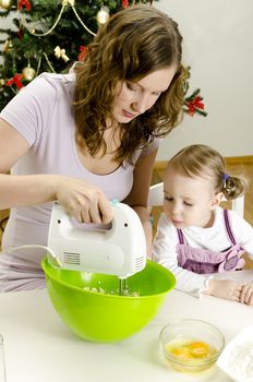 little girl and mother are preparing Christmas cookies