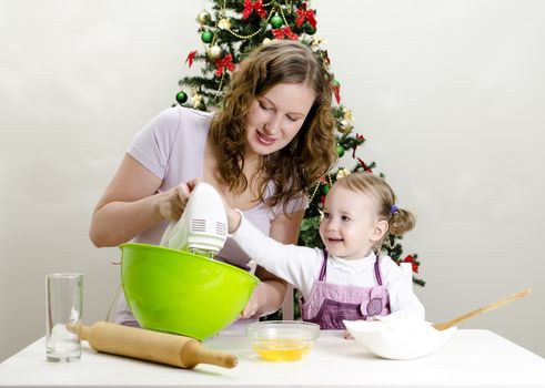 little girl and mother are preparing Christmas cookies