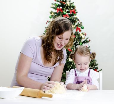 little girl and mother are preparing Christmas cookies