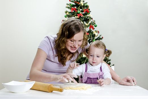 little girl and mother are preparing Christmas cookies