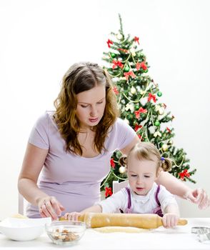 little girl and mother are preparing Christmas cookies