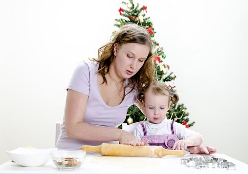 little girl and mother are preparing Christmas cookies