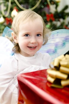 little girl smiling with christmas gift in hand