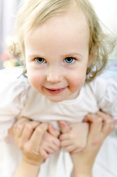 Little playful girl in mother hands
