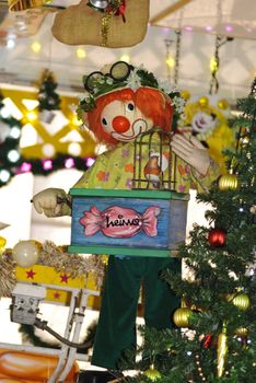Clown playing street organ and holding a bird at Christmas market in Germany