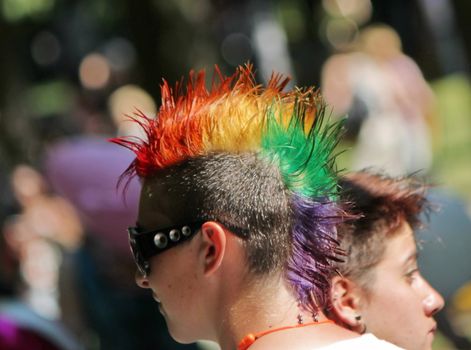 Head of a young woman with colorful punk hair and big black glasses at the Gay Pride 2011, Geneva, Switzerland