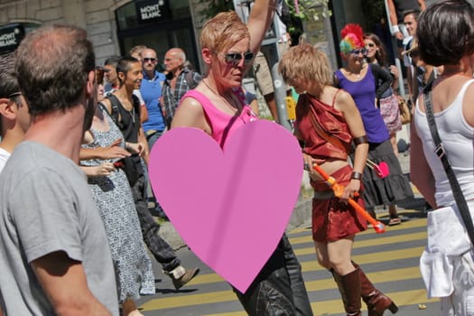 Young woman wearing pink clothes and a big heart while marching at the Gay Pride 2011, Geneva, Switzerland