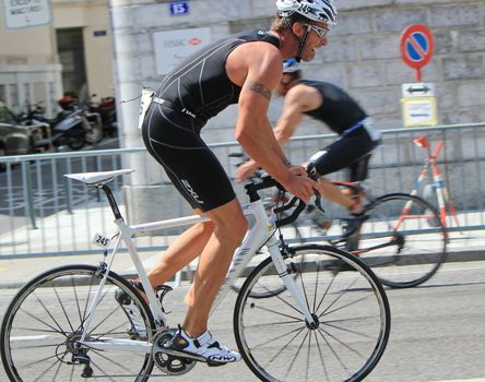 Male cyclist wearing a white helmet at the International Triathlon 2011, Geneva, Switzerland