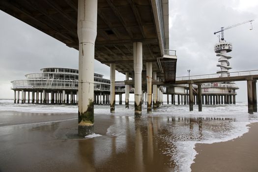 under the pier on a cloudy day on the beach