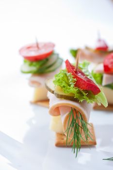 food theme: cracker with ham, cheese and vegetables on the plate