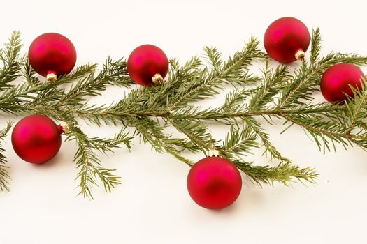 Border of red christmas garland with baubles and ribbons on white.