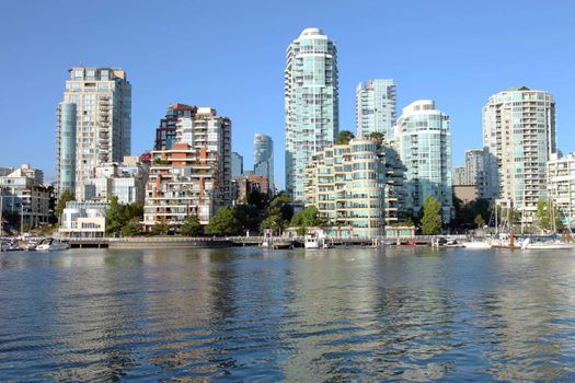 Vancouver BC skyline at False creek high rises and skyscrapers along the waterway.