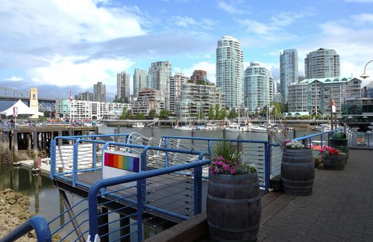 A ferry terminal in Granville island in Vancouver BC., Canada overlooking the skyline across False creek.