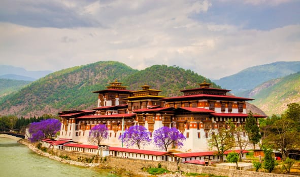 The Punakha Dzong, also known as Pungtang Dechen Photrang Dzong (meaning “the palace of great happiness or bliss” is the administrative centre of Punakha dzongkhag in Punakha, Bhutan. Constructed by Zhabdrung (Shabdrung) Ngawang Namgyal in 1637-38, it is the second oldest and second largest dzong in Bhutan and one of its most majestic structures. The Dzong houses the sacred relics of the southern Drukpa Kagyu school including the Rangjung Kasarpani, and the sacred remains of Zhabdrung Ngawang Namgyal and Terton Padma Lingpa. Punakha Dzong was the administrative centre and the seat of the Government of Bhutan until 1955, when the capital was moved to Thimphu.