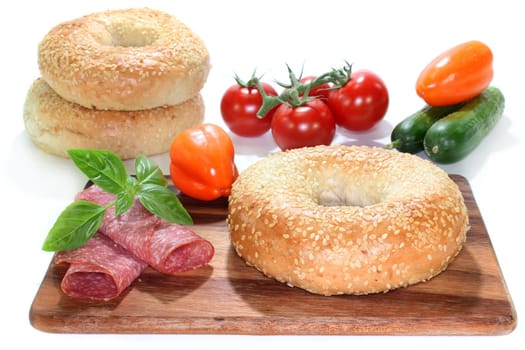 a bagel with salami, bell peppers and cucumber
