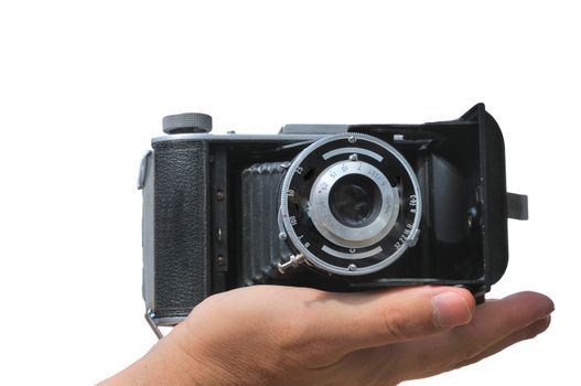 Old camera lies in the palm of the photographer isolated against a white background
