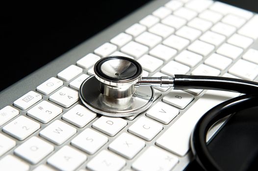 Stethoscope on keyboard on a black table