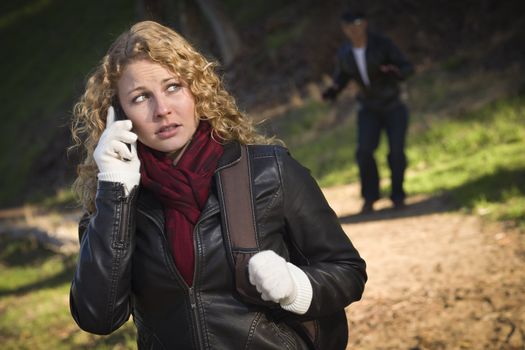 Pretty Young Teen Girl Calling on Cell Phone with Mysterious Strange Man Lurking Behind Her.