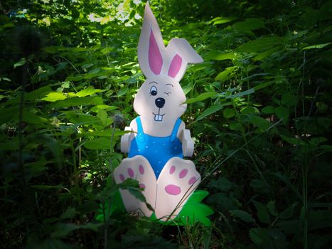 Wooden handpainted Easter rabbit, sitting in grassland