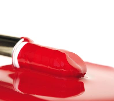 Lipsticks on red liquid .