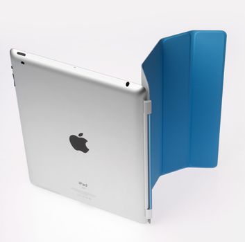 Kiev, Ukraine - June 05, 2011 - Apple Ipad2 with blue Smart cover standing on light gray background. This second generation Ipad 2 is designed and development by Apple inc. and launched in march 2011. Apple iPad2 with folded Smart cover, isolated on light gray.