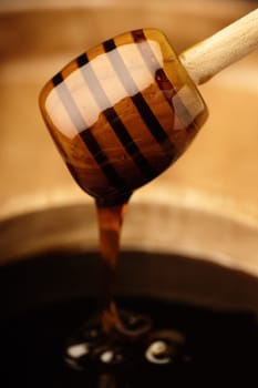 Smooth dripping honey from a wooden dipper