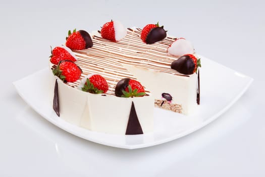 Cheesecake with chocolate and strawberries on the white plate