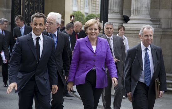 PARIS, FRANCE - JUNE 11 - 2009: French president Nicolas Sarkozy ( left) and German chancellor Angela Merkel ( middle) outside the Elysee Palace on their way to lunch.
