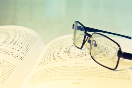 Closeup of opened book and glasses