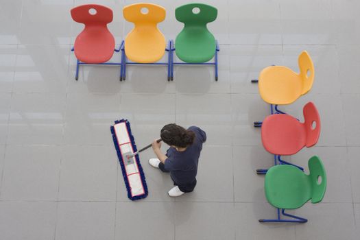 A worker is cleaning the floor with equipment