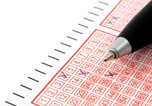 close-up of lottery ticket and ballpoint pen
