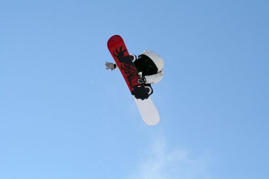 Young snowboarder jumping high in the air