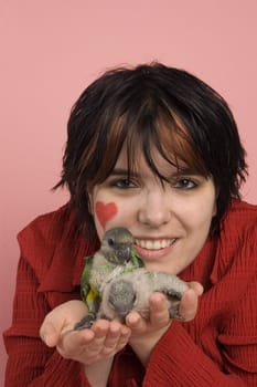 beautiful woman holding baby parrot