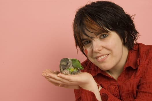 beautiful woman holding baby parrot