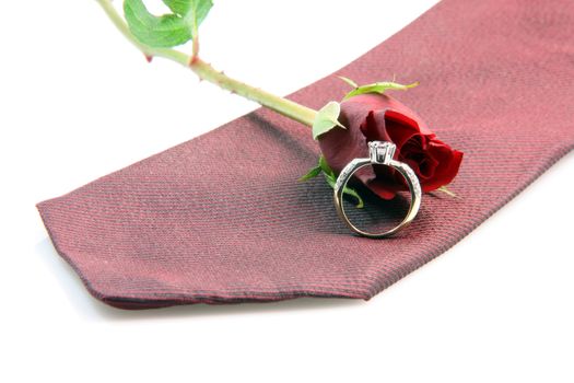 wedding proposal equipment diomond ring, red silk tie and red rose on white background vertical