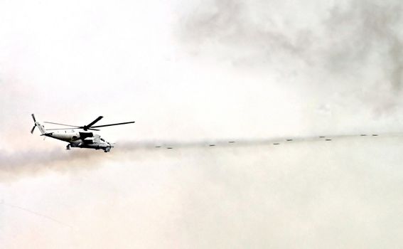 flying military  helicopter shoots