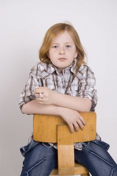 liittle girl sitting on a chair smoking a cigaret