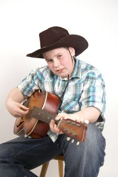 young handsome cowboy playing the guitar
