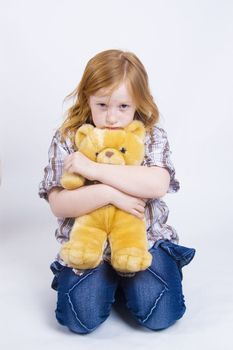 sad girl is holding her dearest teddy bear