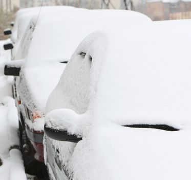 cars covered by snow. winter in the city