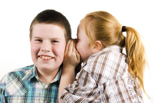young girl is whispering in boys ear