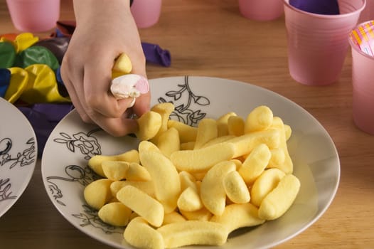 hand is taking candies of a plate