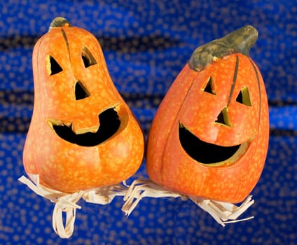 Two funny halloween pumpkins on glittering blue background