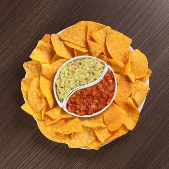 Cheese flavored nachos with guacamole (sauce based on avocado) and tomato salsa 