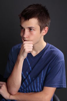 A boy sitting and thinking intensely