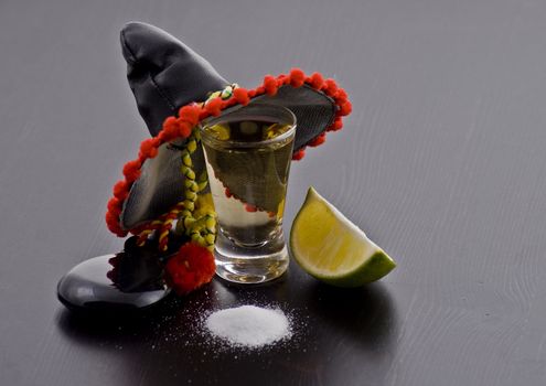 Shot glass of the tequilla with Mexican hat, salt and lime 